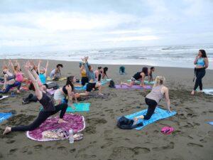 A group practices yoga on the beach